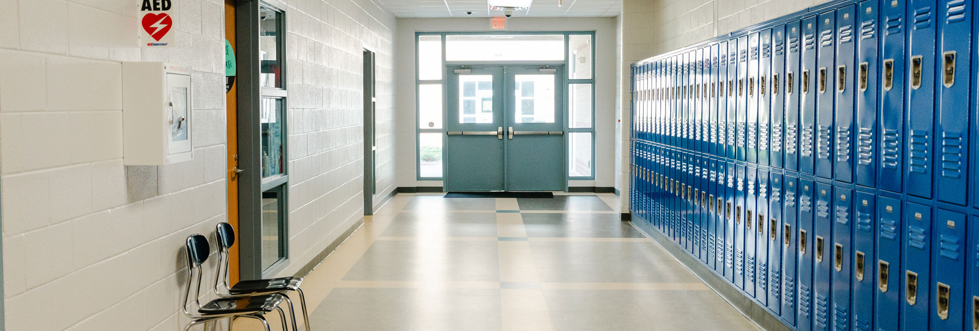 A hallway with blue Lockers and a white wall at the Beaufort County Schools May River High School