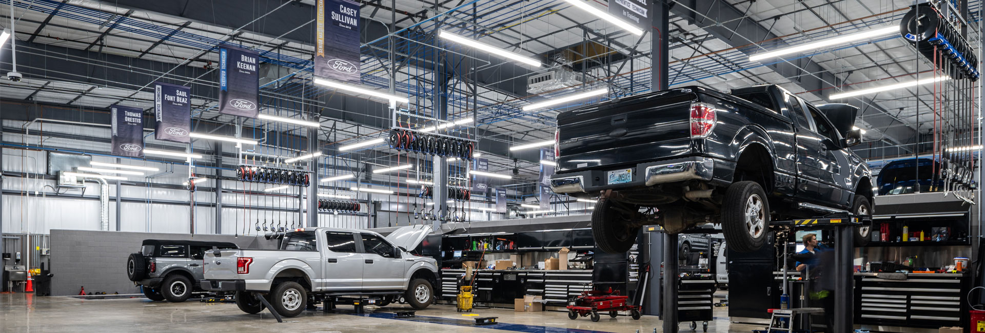 Interior of the service garage with beams and banners hanging from the large vaulted ceilings at Ferman Countryside Ford built by Ajax Building Company